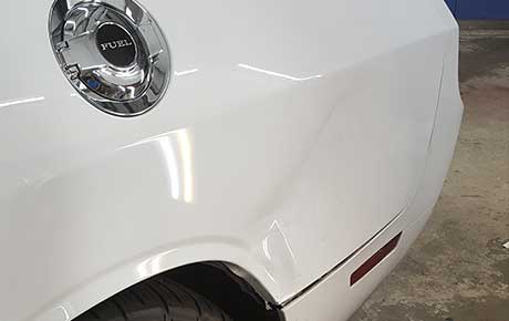 Sharp dent on drivers side rear fender.  We are able to make it look good as new!